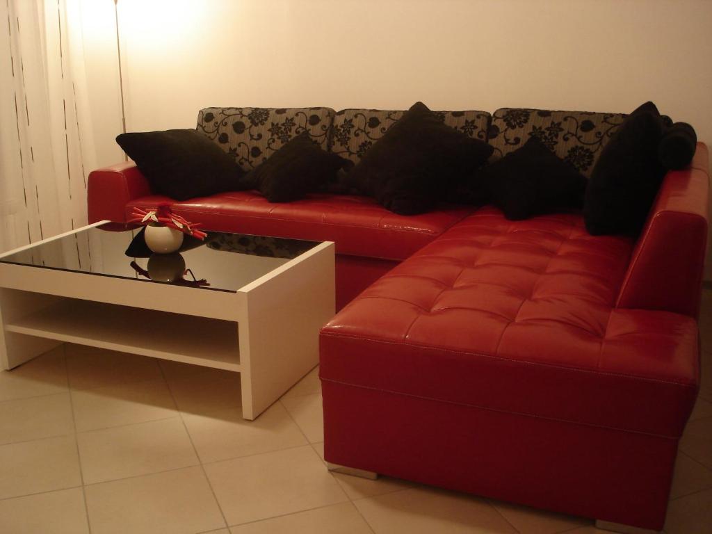 a red couch and a coffee table in a living room at Apartment Lošč - Podbela in Breginj