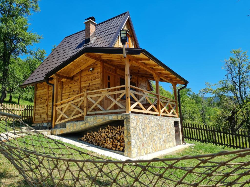 eine Blockhütte mit einem Kamin in einer Hängematte in der Unterkunft Guest House Rankić in Mokra Gora