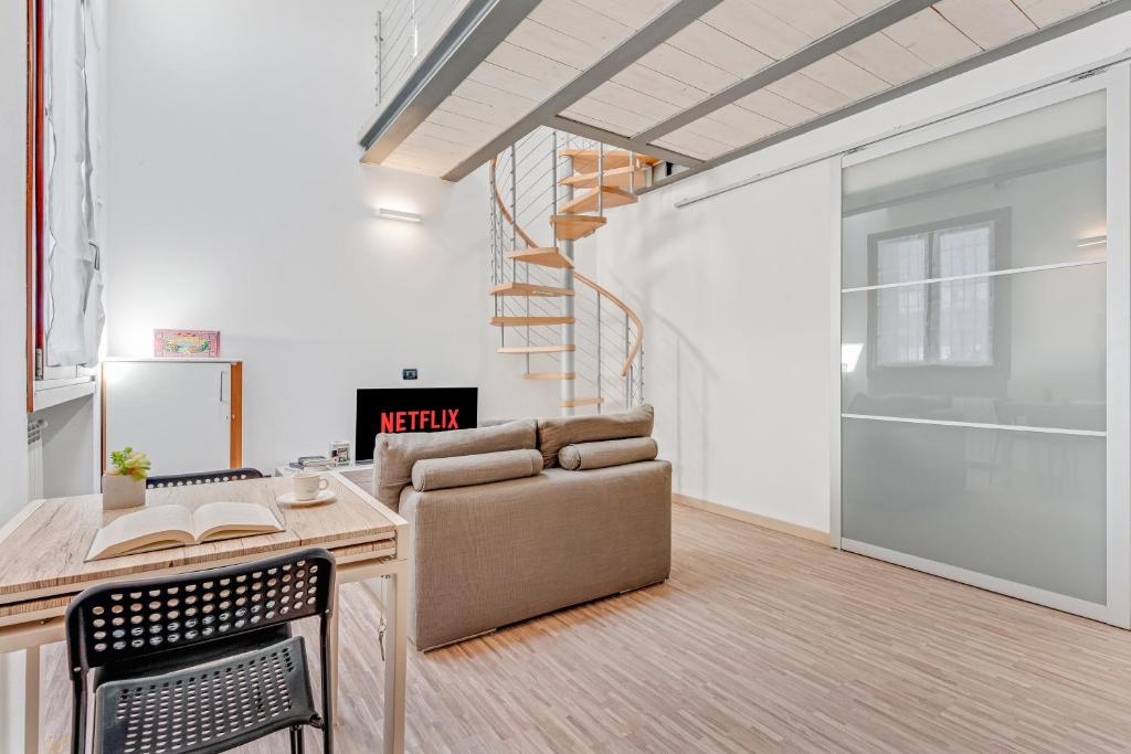 uma sala de estar com um sofá e uma escada em Honey Loft [Milano-Como-Svizzera] em Seregno