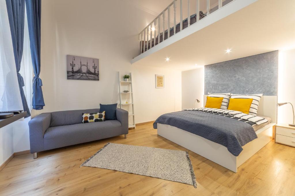 ein Schlafzimmer mit einem Bett und einem Sofa in der Unterkunft Lovely 1 bedroom flat with central location in Budapest
