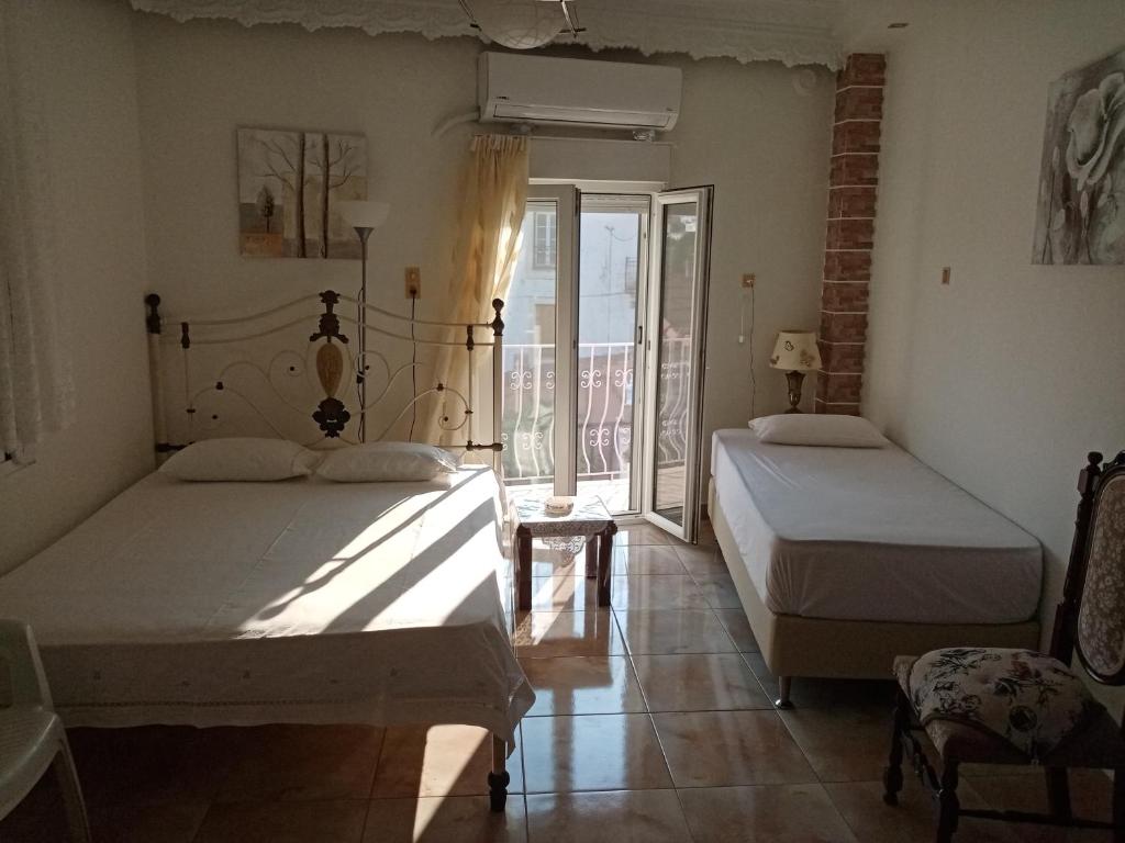 a bedroom with two beds and a balcony at Villa Anna in Tríkeri