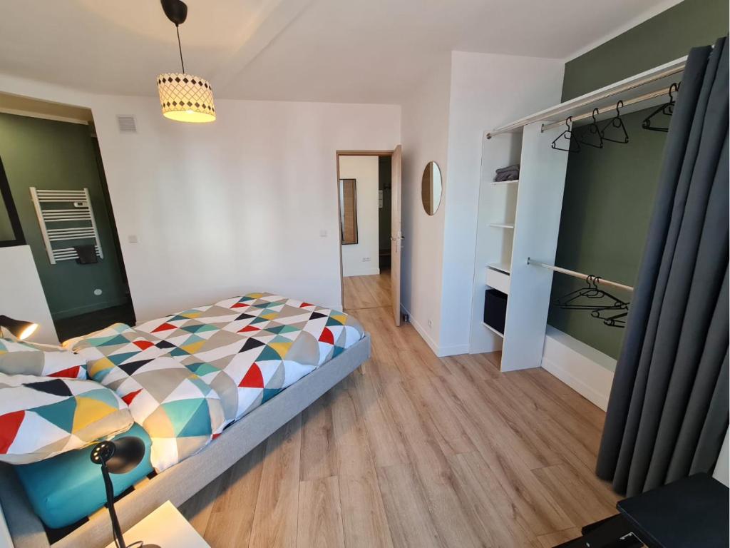 um quarto com uma cama com um edredão colorido em Le ScottmanHouse - Appartement privé - Centre ville - Gare - Wi-Fi em Arras