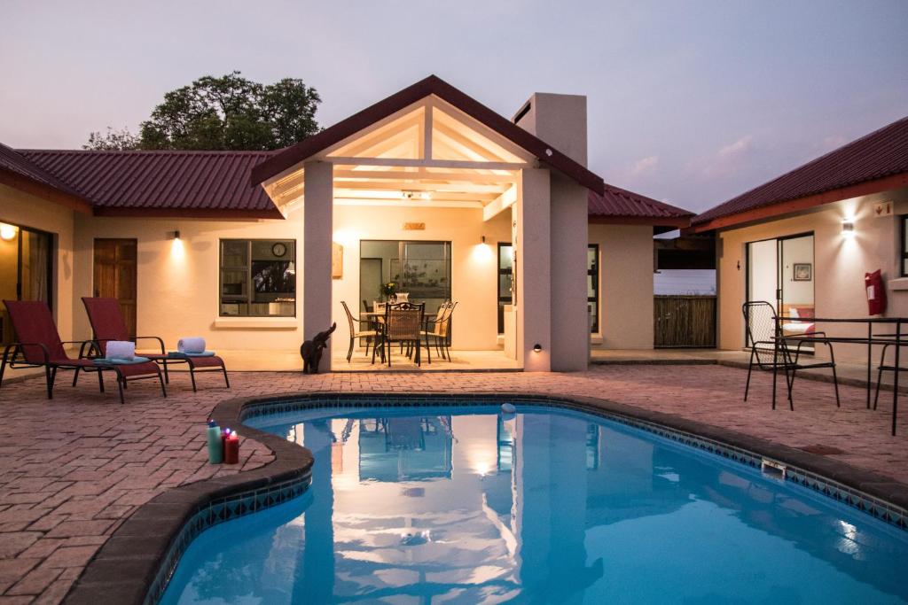 a swimming pool in front of a house at Sentosa Place in Hoedspruit