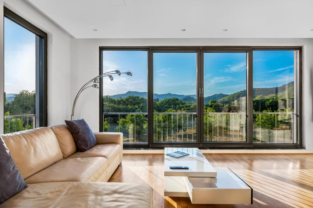 マリボルにあるContemporary apartment with rooftop terrace in Mariborのソファと大きな窓のあるリビングルーム