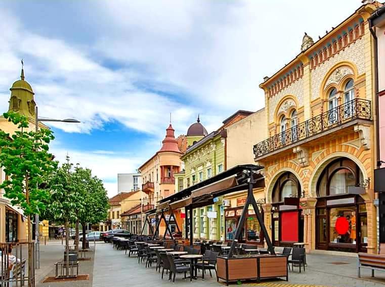 a street with tables and chairs on a city street at Centar lux 2 in Zrenjanin