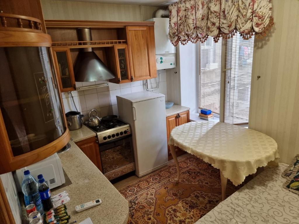 a kitchen with a refrigerator and a table in it at Apartament centru in Chişinău