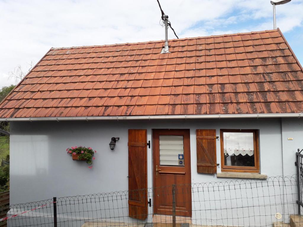 une maison blanche avec un toit rouge et une fenêtre dans l'établissement Gîte "Le Rucher", à Romanswiller