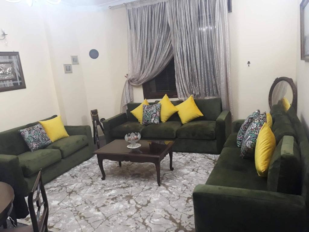 a living room with green couches and a coffee table at Maison vintage Rabat Agdal in Rabat