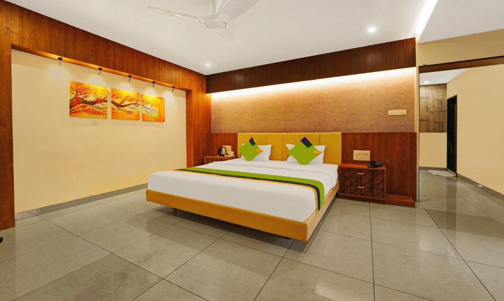 a bedroom with a large bed in a room at Treebo Trend Surya Comforts 200 Mtrs From Kolhapur Railway Station in Kolhapur