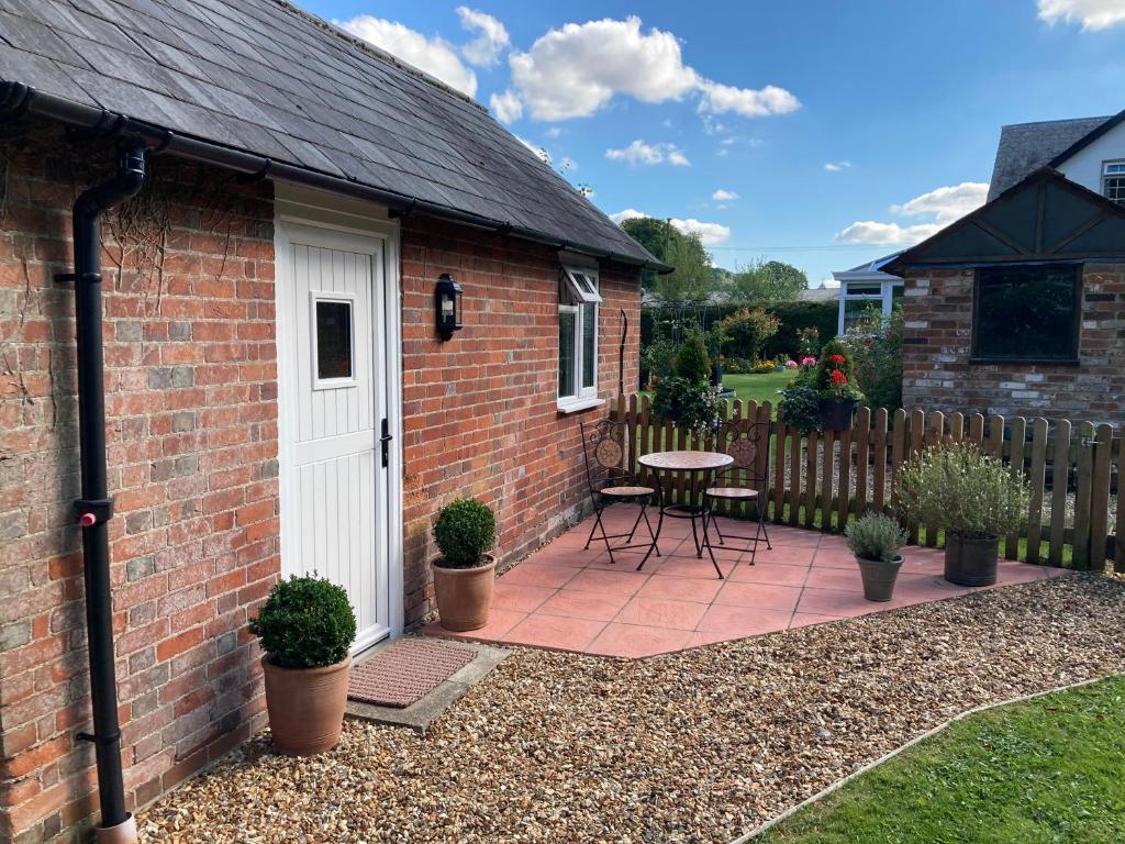 a brick house with a white door and a patio at Hunters Moon B&B in North Tidworth