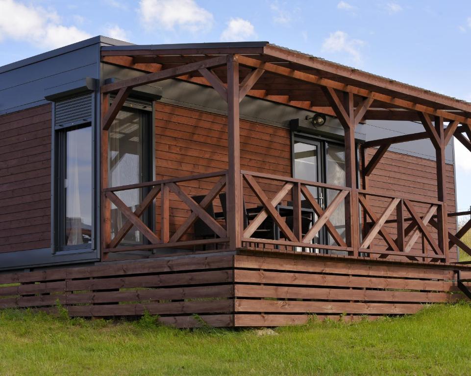 a log cabin with a timber roof and a deck at B10 Pan i Pani Żuraw nad Jeziorem in Ełk