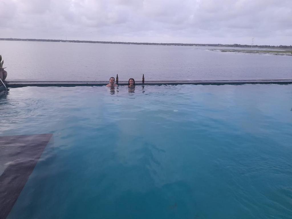 two people swimming in a large body of water at Oruwa Boutique Villas in Arugam Bay