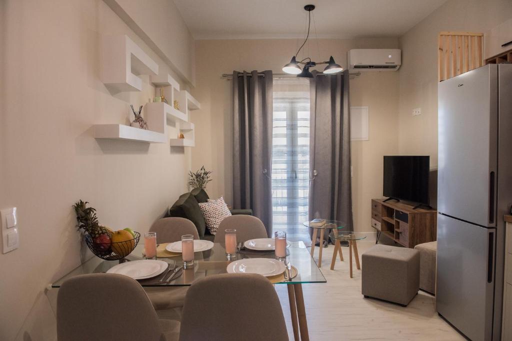 a kitchen and living room with a table and a refrigerator at Boboli Holiday House Acharavi Corfu in Acharavi