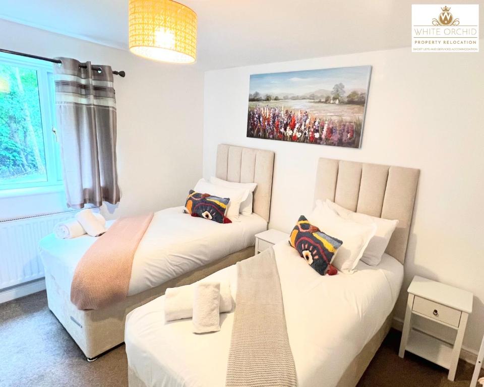 a room with two beds and a table in it at Contractors 2 Bed Apartment in Stevenage near Asda By White Orchid Property Relocation Leisure & Business in Stevenage