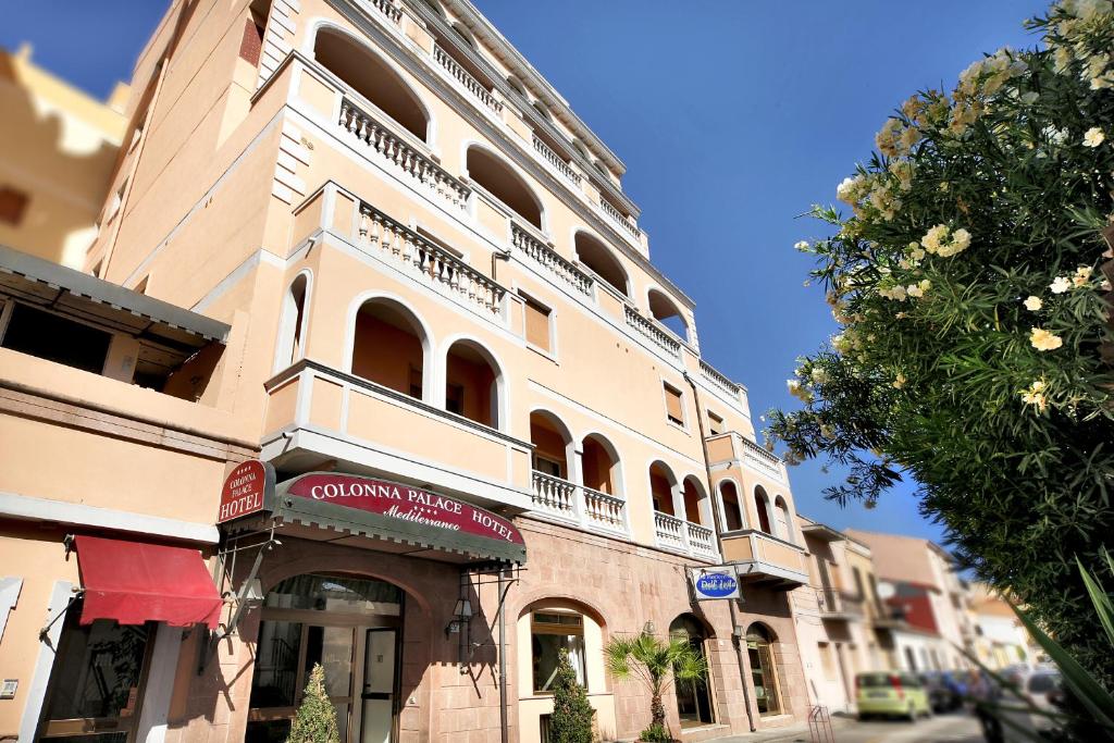 Un palazzo alto con un cartello sul lato. di Colonna Palace Hotel Mediterraneo a Olbia