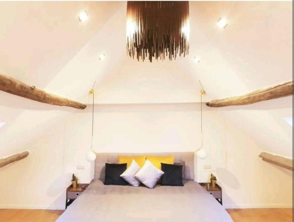 ein Schlafzimmer mit einem weißen Bett und zwei Nachttischen in der Unterkunft Beautiful Duplex in the center of Brussels in Brüssel