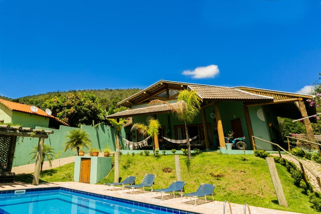 a house with a swimming pool in front of it at Recanto Namastê - Hospedagem in Cunha