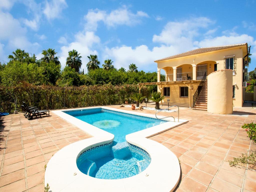 a swimming pool in front of a house at Villa Tanya in Málaga