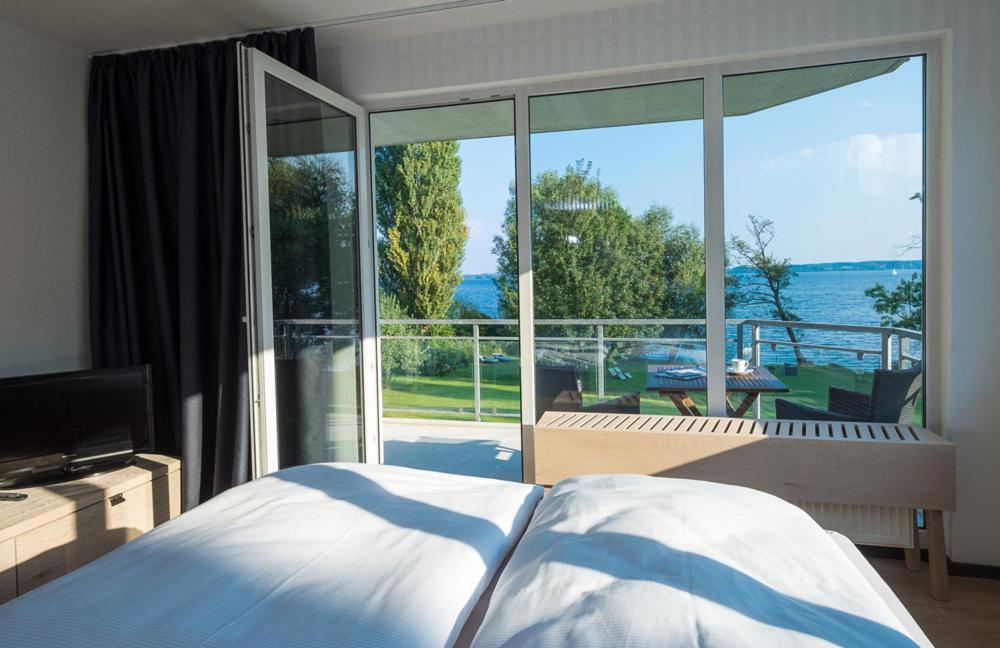 a bedroom with a bed and a large glass window at Design-Suite am See in Ascheberg