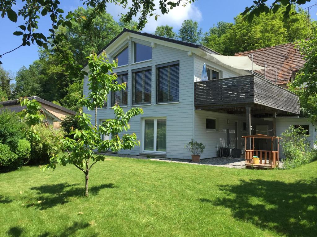 ein Haus mit einer Terrasse auf einem Hof in der Unterkunft Hoeri Ferienhaus -Lake Constance in Öhningen