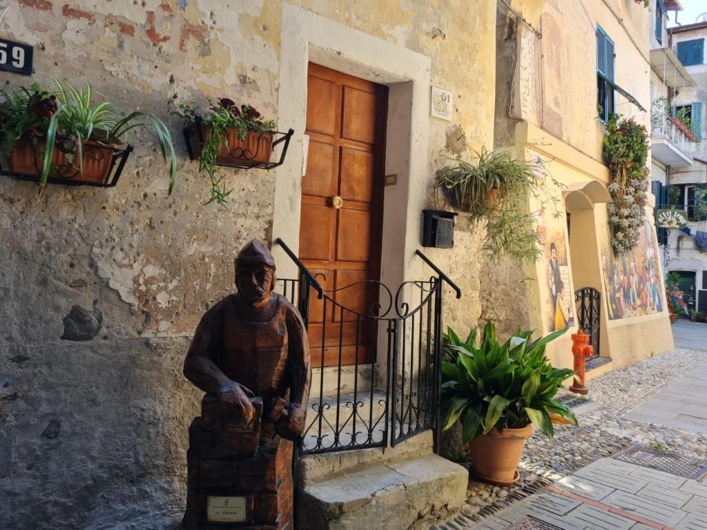 una estatua delante de un edificio con una puerta en Rifugio dei Saraceni en Vallecrosia