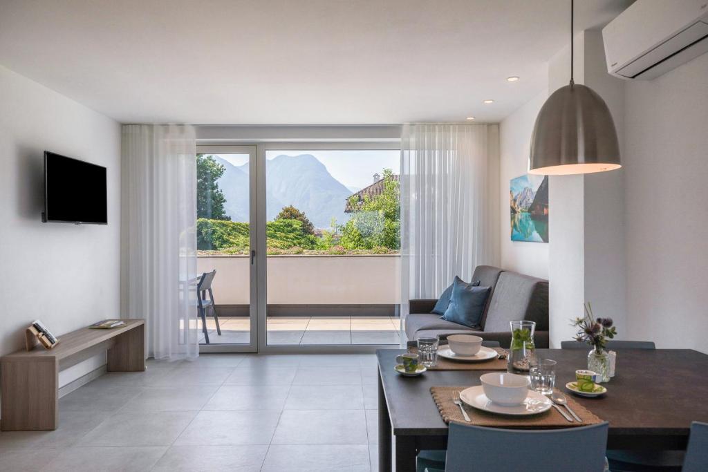 Apartments Curti - Himmelblau في لايفيس: غرفة معيشة مع طاولة طعام وغرفة معيشة
