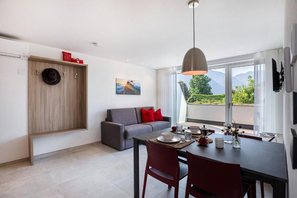 uma sala de estar com uma mesa de jantar e um sofá em Apartments Curti - Abendrot em Laives