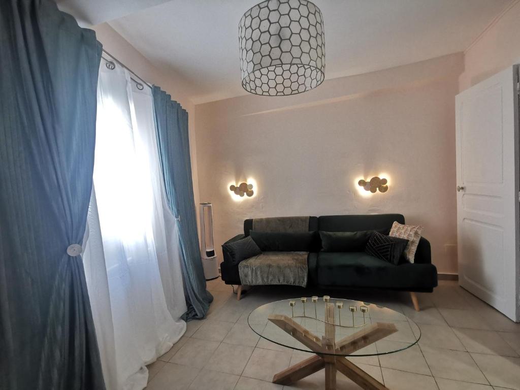 a living room with a black couch and a glass table at Ness Home A Beautiful Village House in Maraussan