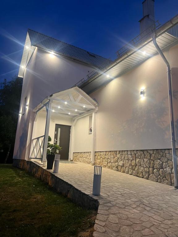 a white building with a tent with lights on it at Prorok Agroturystyka in Tereszpol