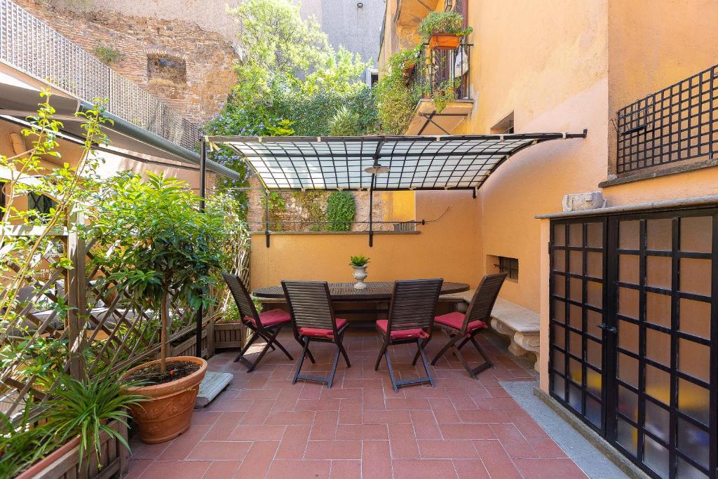 a patio with a table and chairs in a courtyard at Ciambella Art Home-Rental in Rome in Rome