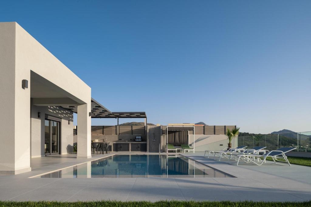 vistas a un edificio con piscina en Eolides Villas , Quite Idyll of Rural Bliss,By ThinkVilla en Lambiní