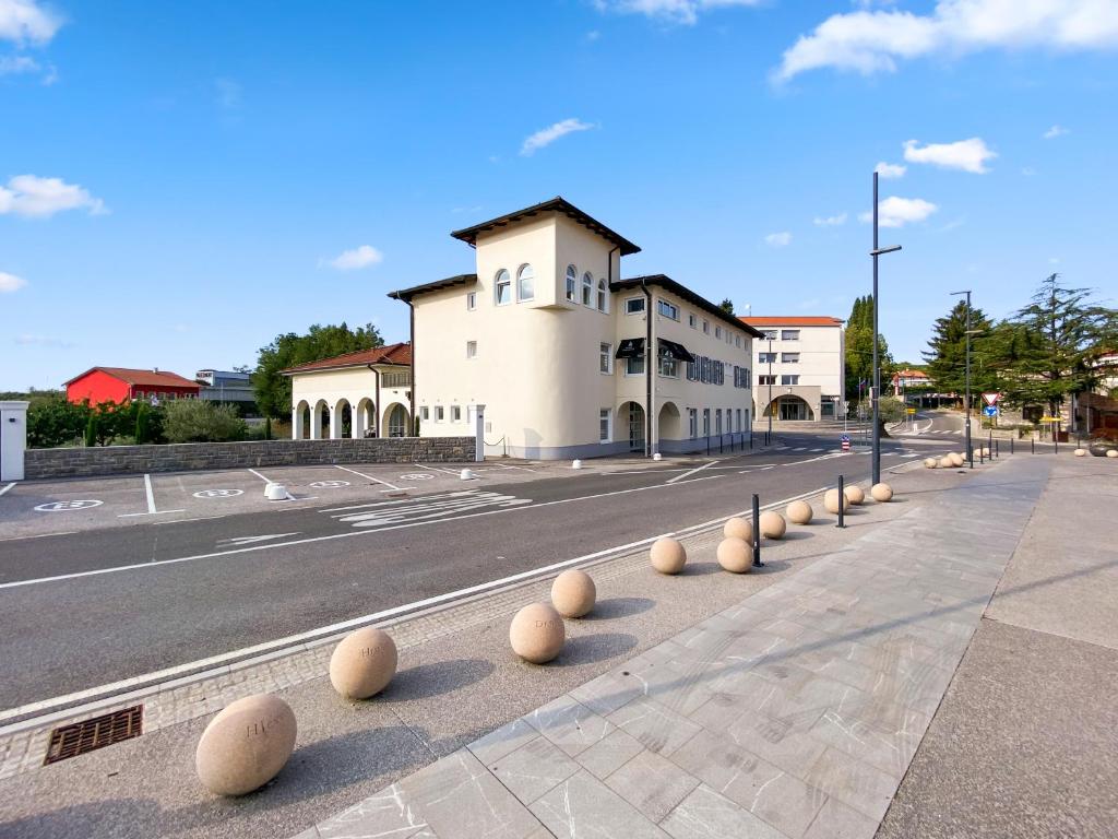 a street with a building with balls on the sidewalk at TOSCANINA Garni Hotel in Dobrovo