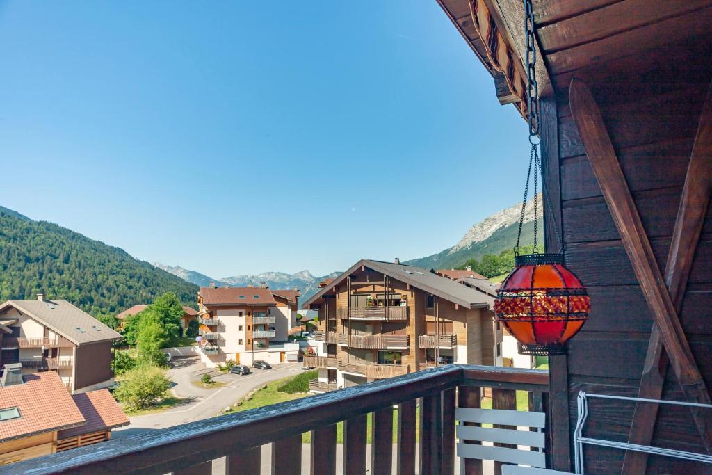 a balcony with a view of a town with mountains at Tournette Montagnes et Lacs in Saint-Jean-de-Sixt