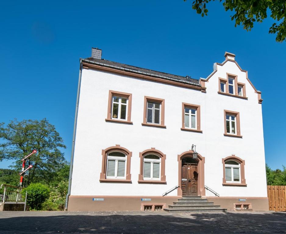 a large white building with a door on it at Glaadter Hütte in Jünkerath