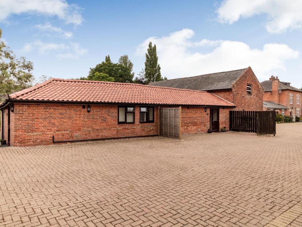 a brick house with a brick driveway at The Nest Box in Diss
