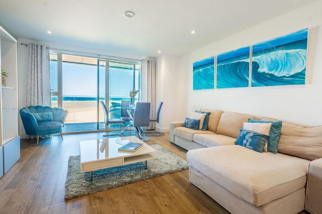 a living room with a couch and a table at Luxury beach apartment in Perranporth