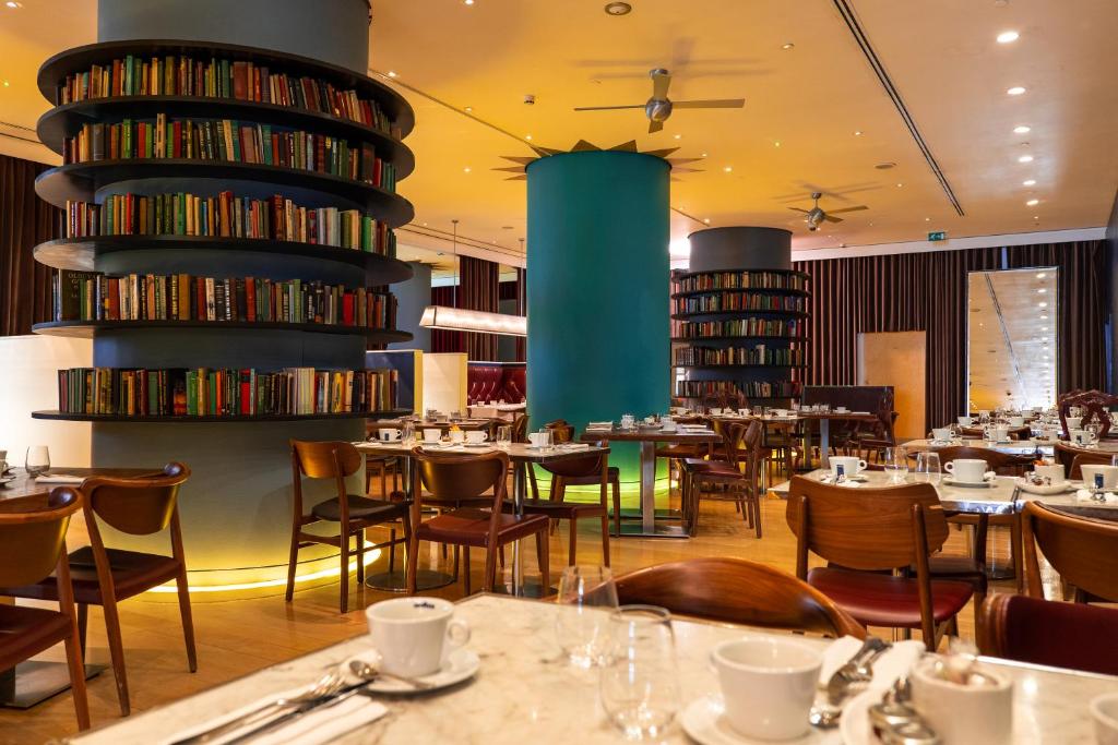 a restaurant with tables and chairs and books at St Martins Lane London in London