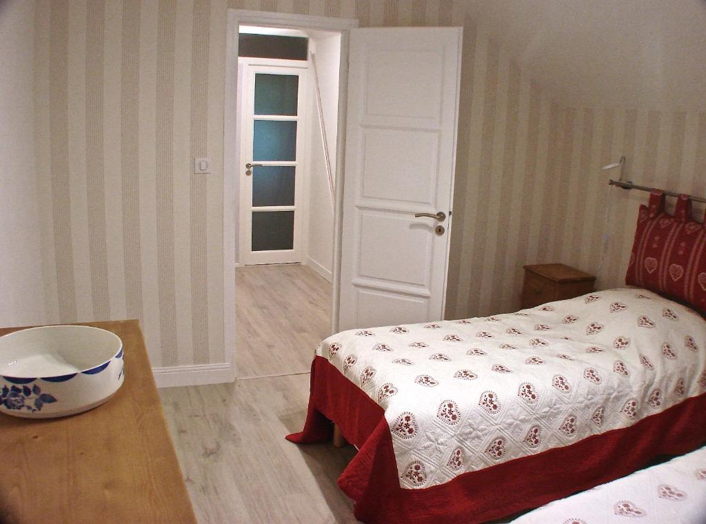 um quarto com uma cama, uma mesa e uma porta em Villa Eth Mayouret em Cauterets