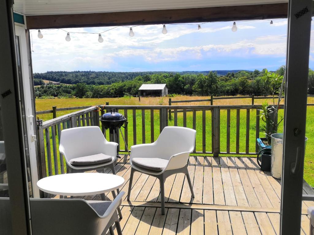 una terraza con sillas y mesas y vistas a un campo en Séjour au calme en pleine nature, 