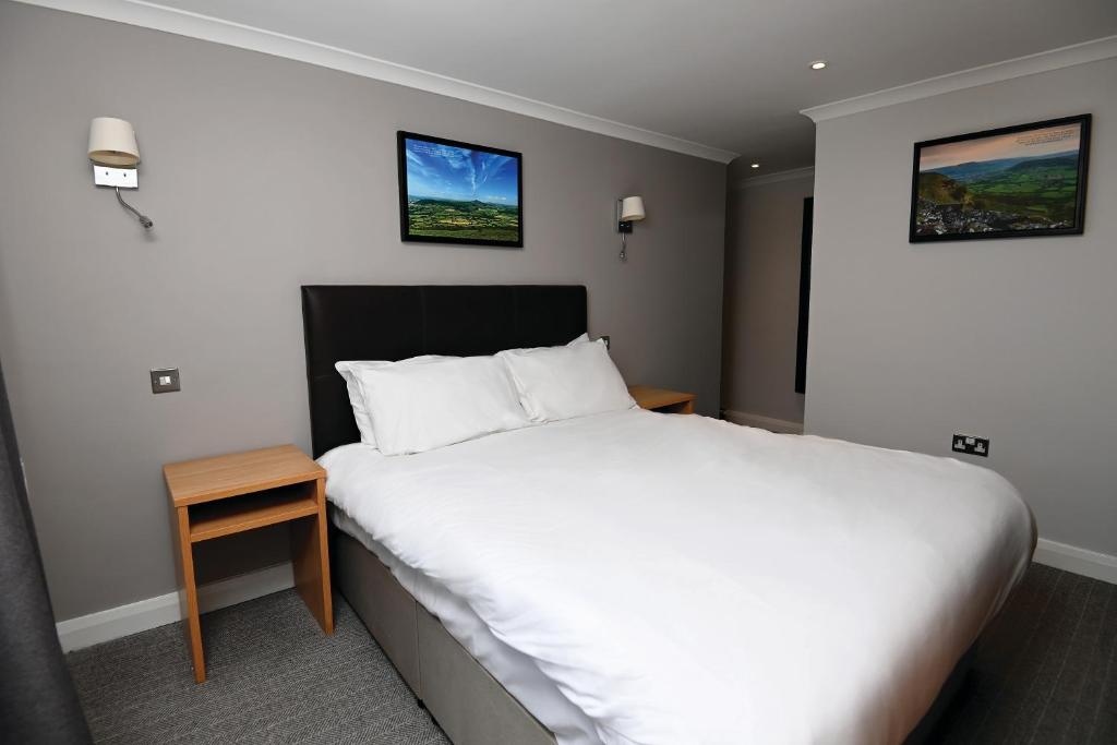 a bedroom with a large white bed and a table at Lamb & Flag Inn in Abergavenny
