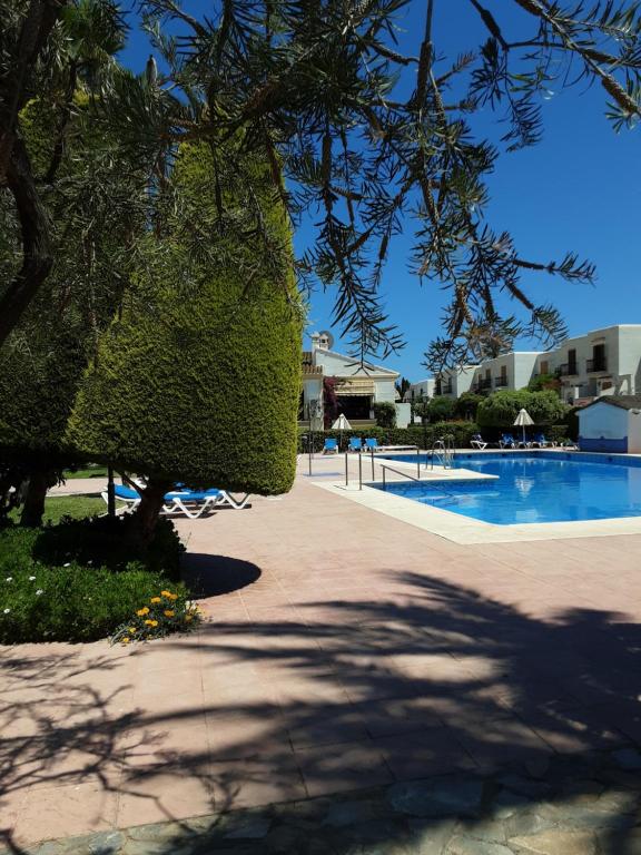 um resort com uma piscina e uma árvore em Casa sol y mar em Vera