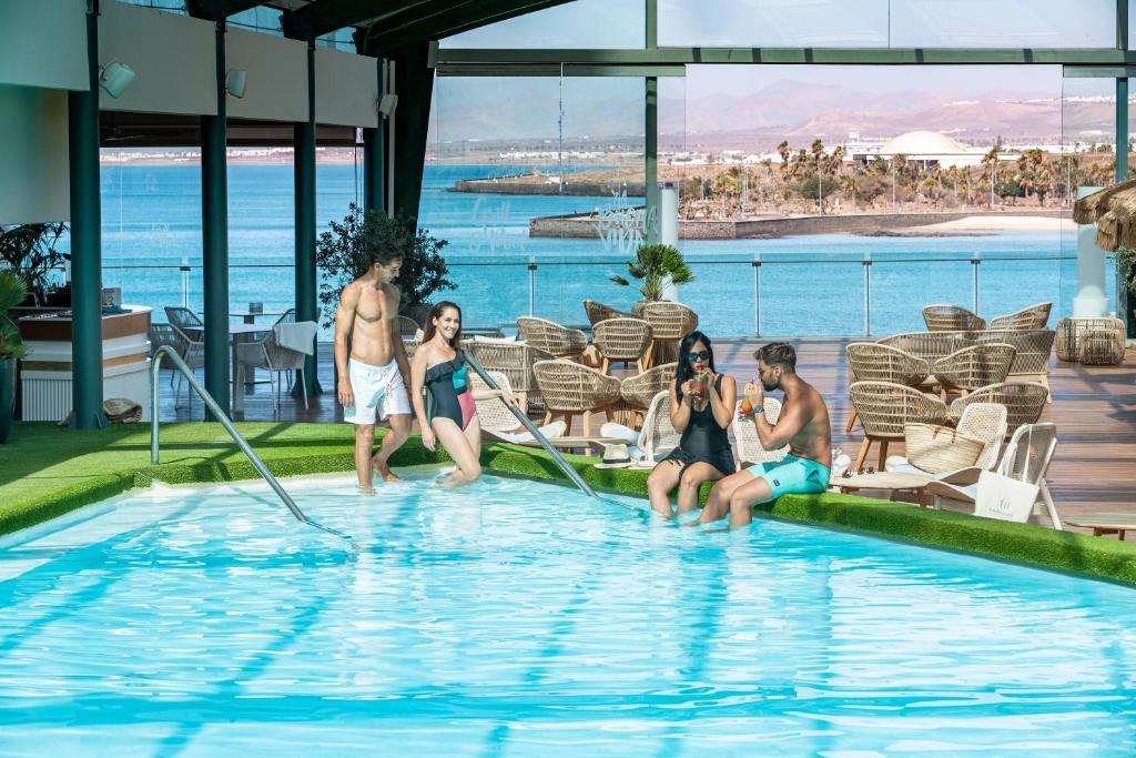 a group of people sitting in a swimming pool at Arrecife Gran Hotel & Spa in Arrecife