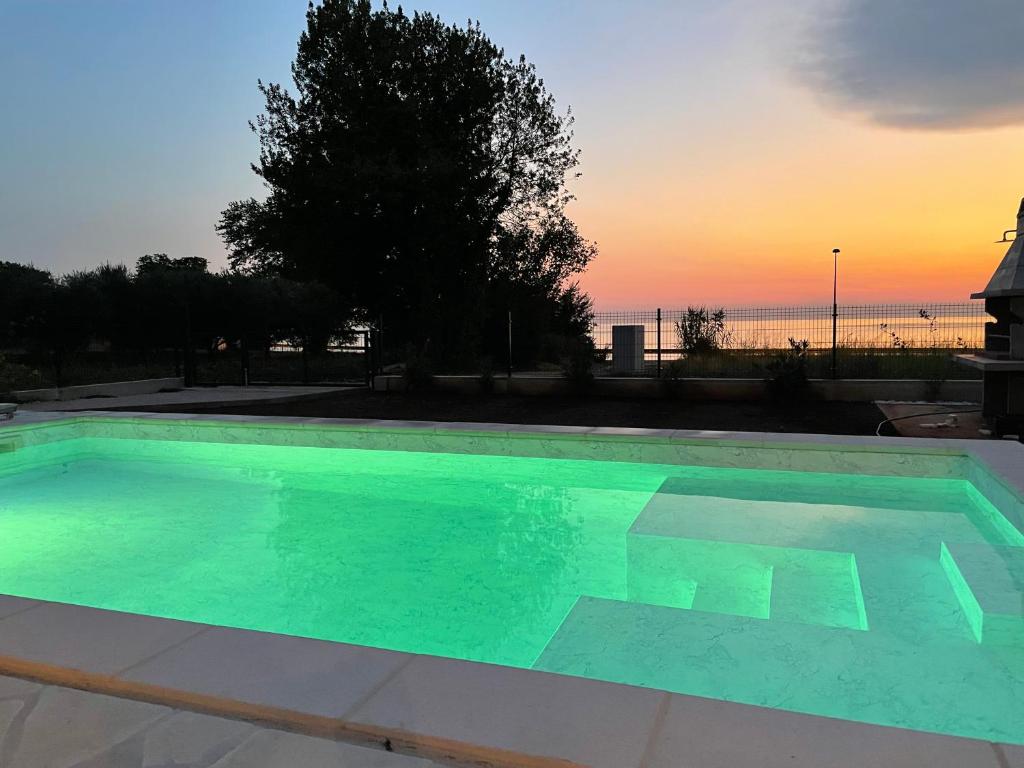 a swimming pool with a sunset in the background at Casa Giovanna in Umag