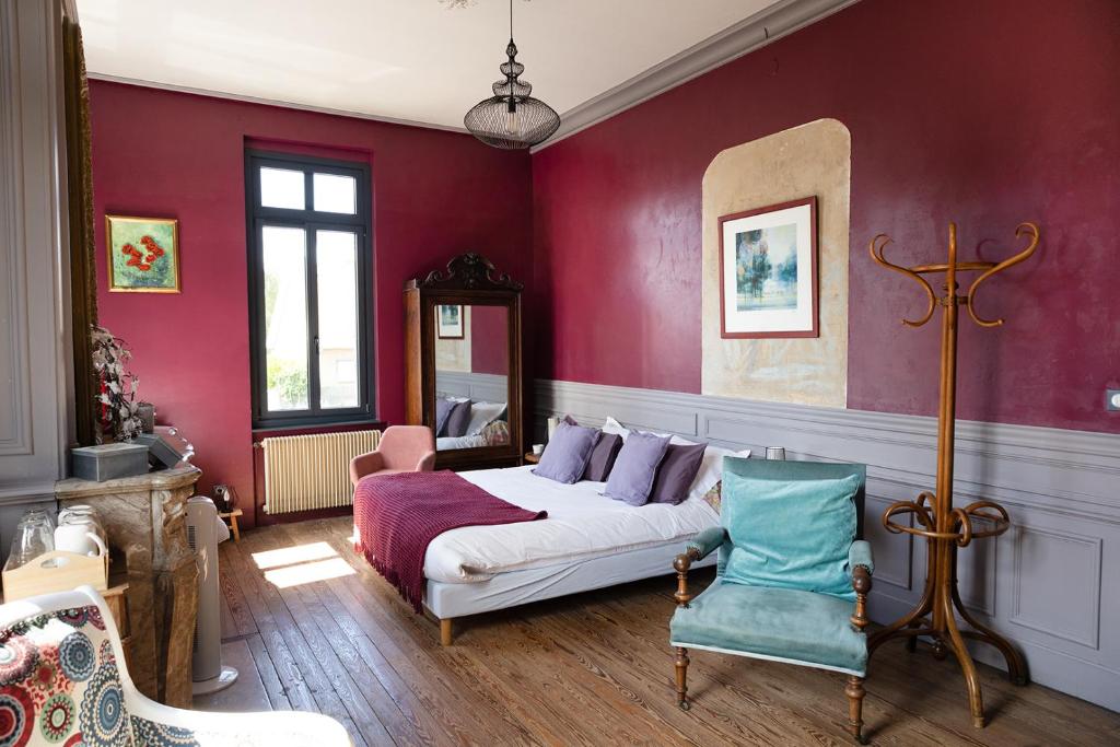 a bedroom with a bed and a chair at La maison au fil du temps in Pont-Rémy