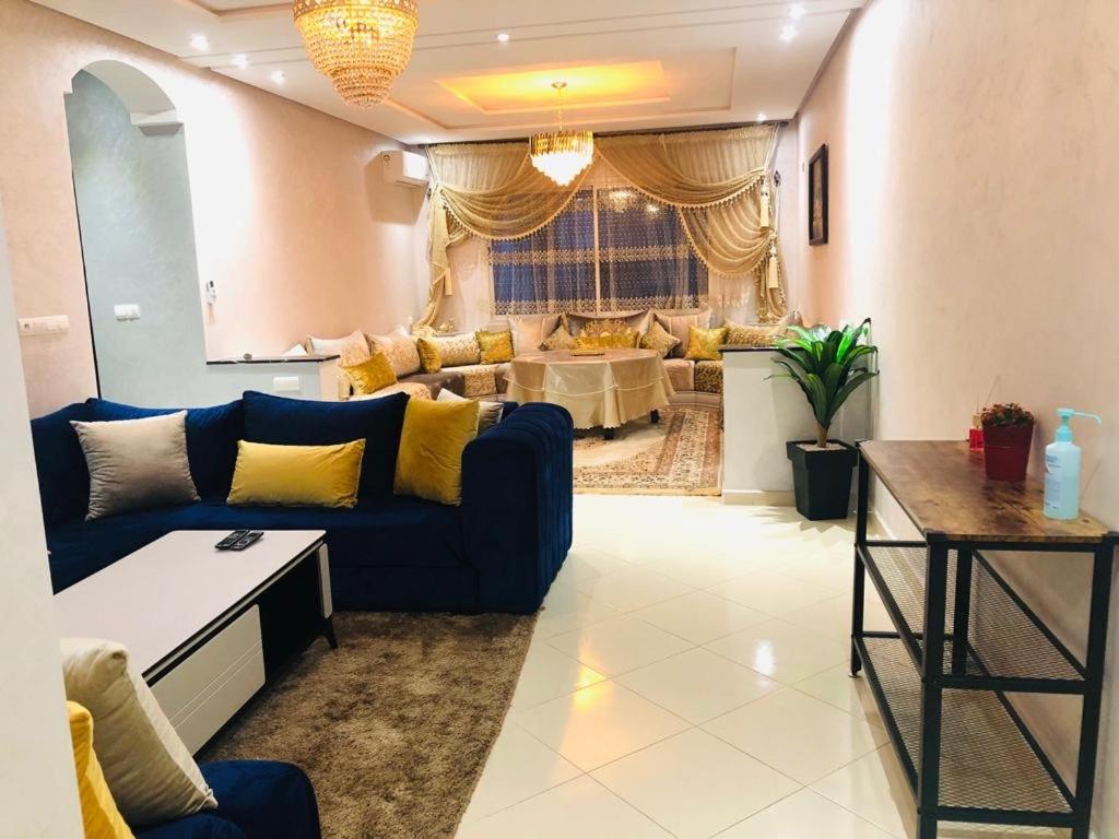 a living room with a blue couch and a table at appartement founty Agadir in Agadir