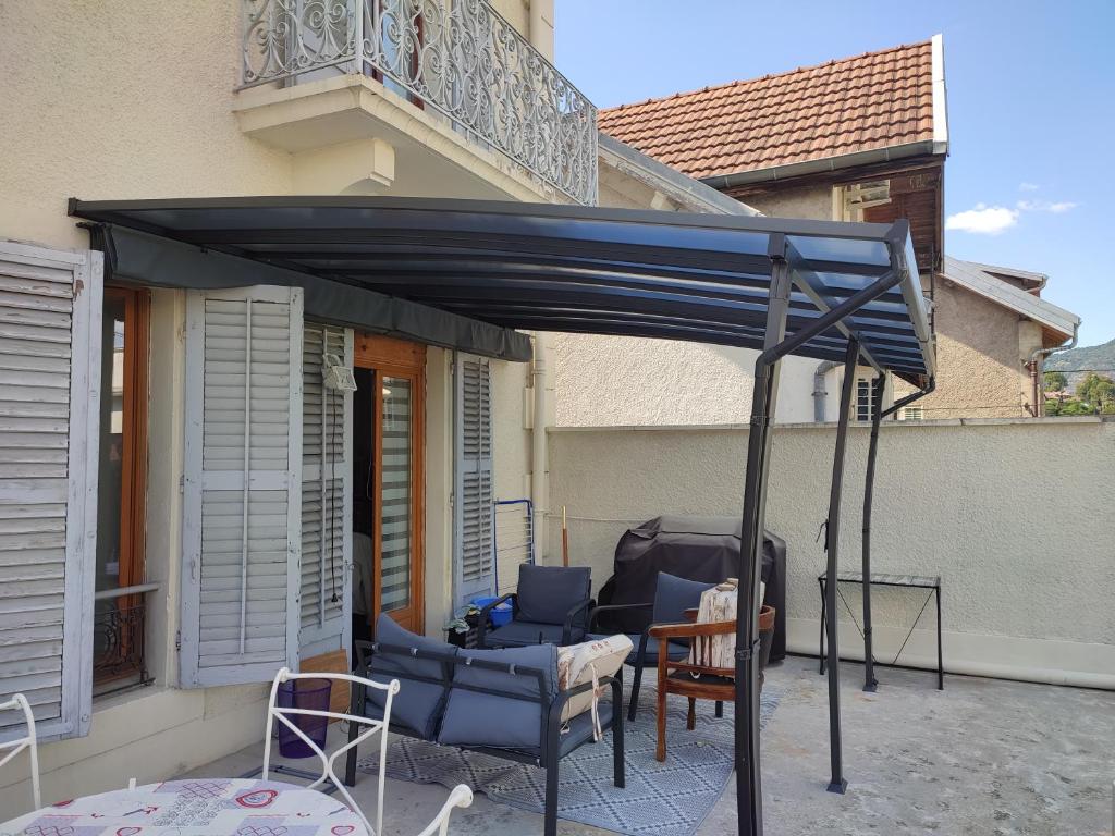 - un auvent sur une terrasse avec des chaises et une table dans l'établissement bedroom, à Aix-les-Bains