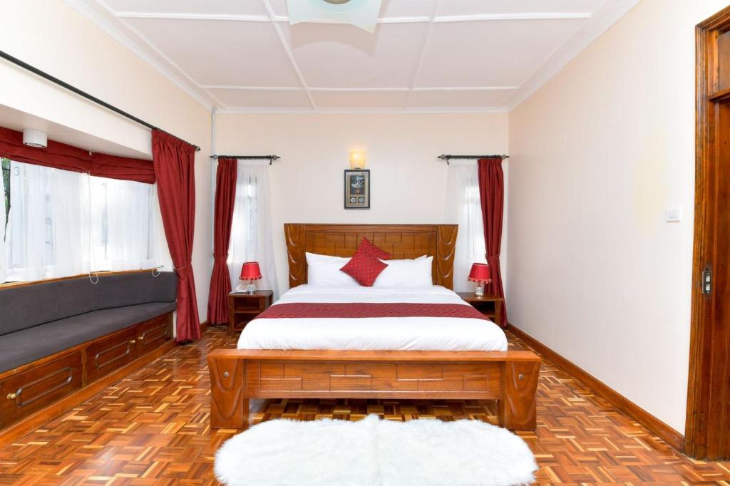 1 dormitorio con 1 cama grande y cortinas rojas en The Premier Suites, en Nairobi