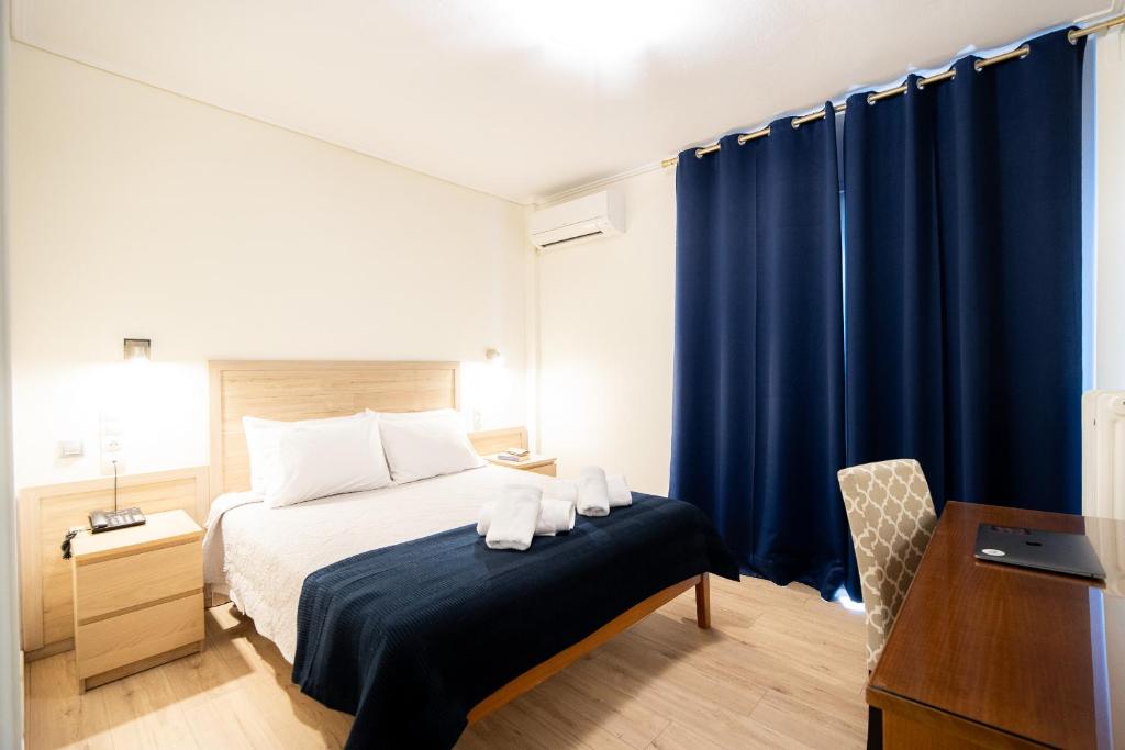 a bedroom with a bed with blue curtains at Hotel Philippos in Volos