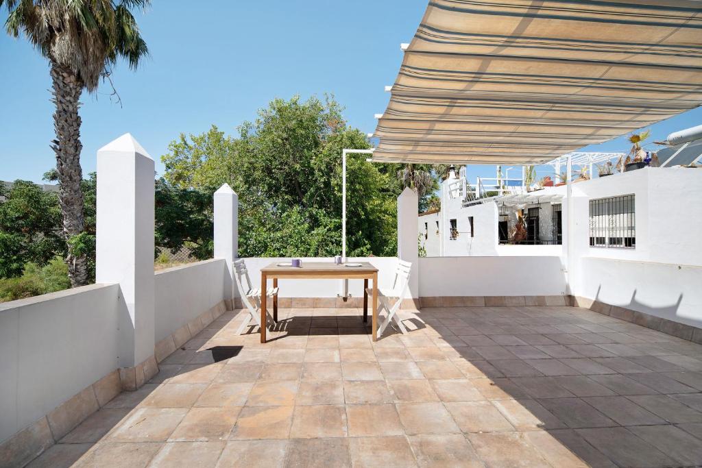 El Trocadero的住宿－Casa La Gaviota，白色墙壁上的带木桌的庭院