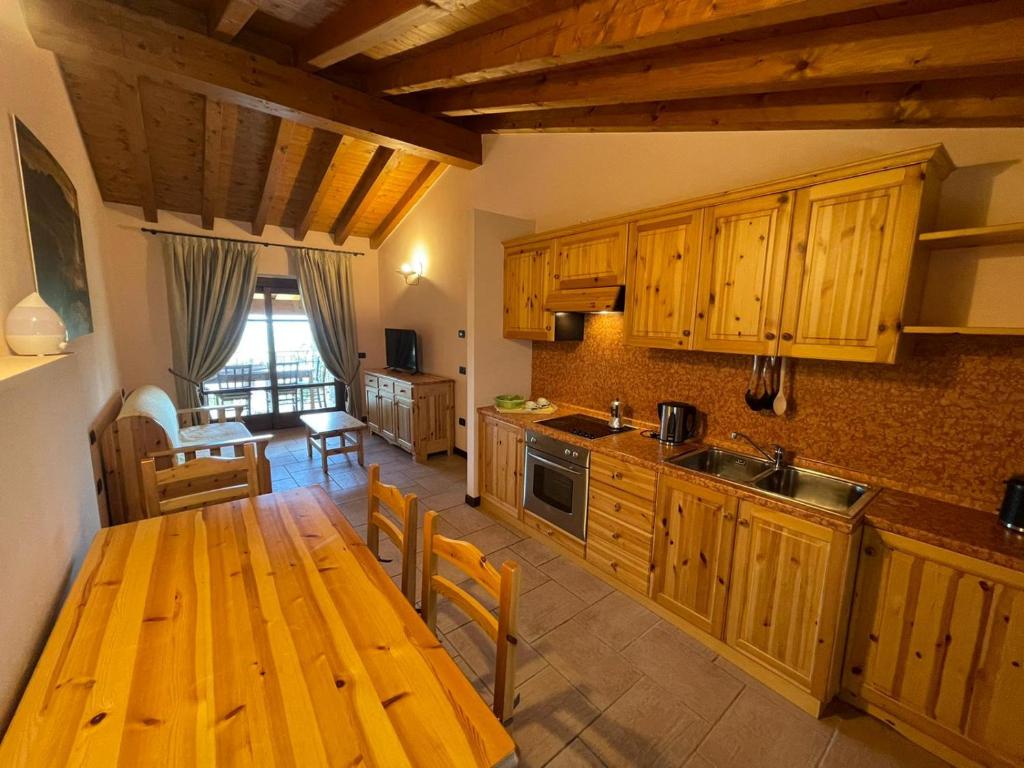 kuchnia z drewnianymi szafkami i drewnianym stołem w obiekcie La FIOCCHINA - Magic Place - apartments & studios in Garda Lake - countryside farmhouse, inside the middle of the lake w mieście Salò